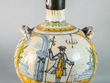 a small vase with a painting on it sitting on a table