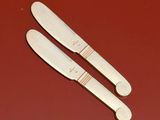 two knives that are sitting on a red surface