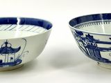 pair of blue and white bowls with designs of pagodas and pagodas on them
