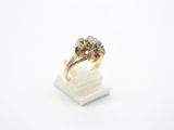 gros plan d'une bague en or avec des diamants sur une surface blanche