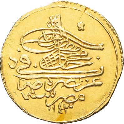 Gros plan sur une pièce d'or portant une écriture arabe
