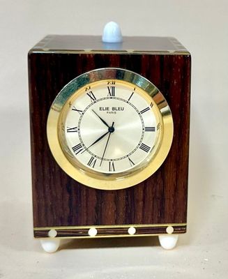 a small wooden clock with roman numerals on it