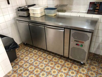 un plan de travail en acier inoxydable dans une cuisine équipée d'un lave-vaisselle