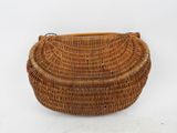 a brown wicker purse on a white background with a wooden handle