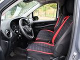 the interior of a small car with a red and black seat cover