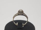 a close up of a ring with a diamond on top of a black stand