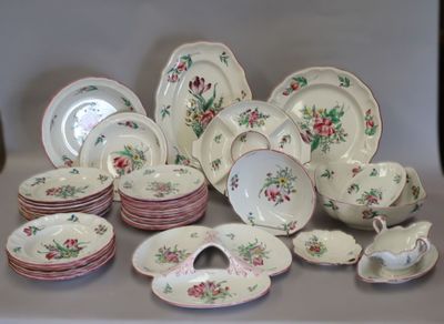 de nombreuses assiettes et bols posés sur la table, décorés de fleurs