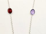 a necklace with multi colored stones on a silver chain