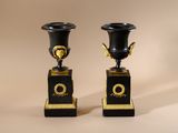 pair of black and gold vases sitting on top of each other