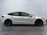 a white tesla model 3 parked in a parking lot