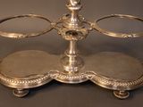 a silver plate with a candle holder on top of it