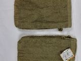 deux morceaux de tissu vert munis d'étiquettes, posés sur une surface blanche