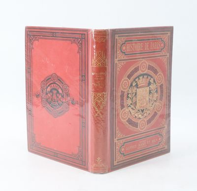 un vieux livre à la couverture rouge posé sur une surface blanche