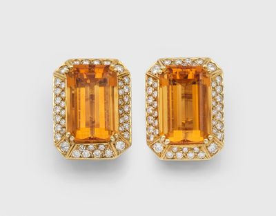 a pair of orange sapphire and diamond earrings