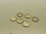 plusieurs pièces d'or posées sur une surface blanche