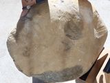 a person standing next to a large rock with a knife in it