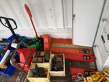 un tas d'outils posé par terre à côté d'un chariot élévateur
