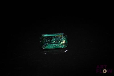une photo d'une émeraude verte dans l'obscurité