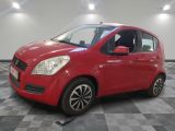 une voiture rouge est garée dans une pièce au sol en damier