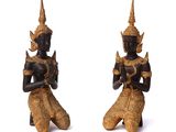 pair of black and gold statues of a man and a woman sitting on their knees