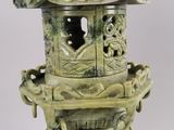 a green vase with a bird on top of it