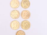 six different types of gold coins on a white surface
