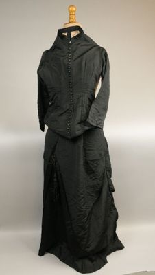 une photo d'une robe et d'une veste noires présentées sur un mannequin