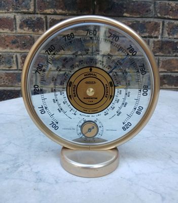 une horloge posée sur une table, avec un mur de briques en arrière-plan