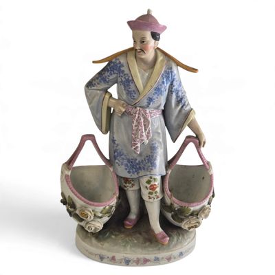 une figurine représentant une femme tenant deux paniers