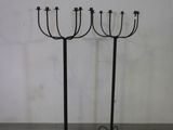 pair of black iron candelabs with four candles on them