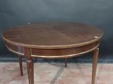 an oval coffee table with a wooden top on a carpeted floor