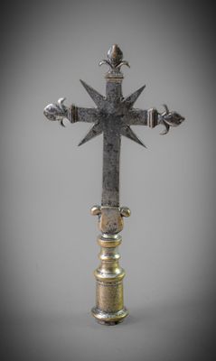an old metal cross with a bird on top of it