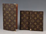 two louis vuittois notebooks, one brown and one brown
