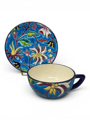 a close up of a cup and saucer on a white background