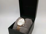 un gros plan d'une montre dans un coffret, sur fond blanc