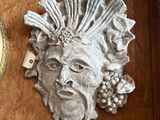 a statue of a man on the wall next to a clock