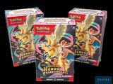 On voit deux boîtes de cartes à collectionner Pokémon sur un fond noir.