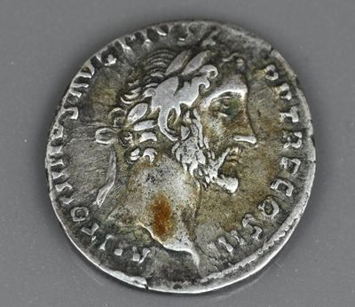 un gros plan d'une pièce d'argent sur laquelle figure l'effigie d'un homme