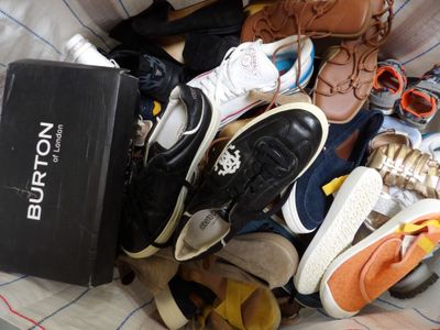 many pairs of shoes in a box on a bed