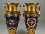 pair of blue and gold vases sitting on top of a white table