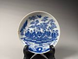 a blue and white plate sitting on a wooden stand