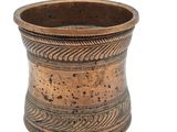an image of a small metal cup with a design on it