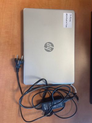 a laptop and a remote on a table next to each other
