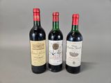 trois bouteilles de vin sont alignées sur une surface grise