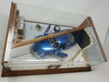 a blue toy car in a glass case on a table
