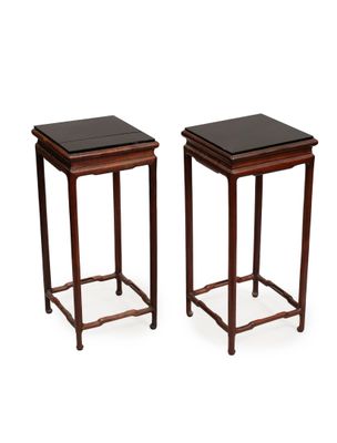 a pair of mahogany side tables with black tops