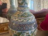someone taking a picture of a vase with a mirror in the background