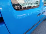 a blue truck parked in a parking lot with other trucks in the background