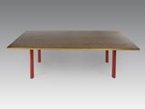 une table en bois aux pieds rouges sur fond gris