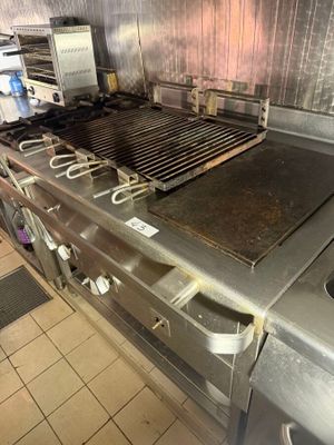 stainless steel counter top in a commercial kitchen with a grill on it